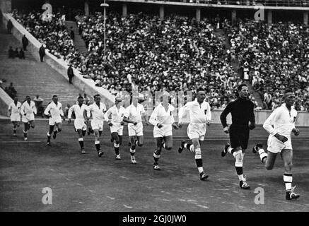 Olympische Spiele 1936, Berlin - die deutsche Handball-Nationalmannschaft läuft zum Jubel der hunderttausend Zuschauer auf dem olympischen Spielfeld zum Endspiel. (Die deutsche Handball-Nationalmannschaft ist unter dem Jubel der Hunderttausend in die olympische Kampfbahn zum Endspiel.) Das deutsche Team besteht aus: Karl Kreutzberg, Arthur Knautz, Willi Bandholz, Hans Keiter, Wilhelm Brinkmann, Rudolf Stahl, Fritz Spengler, Erich Hermann, Günter Ortmann, Wilhelm Baumann, Fritz Fromm, Heinz Körvers, Wilhel Muller, Georg Dascher, Kurt Dossin, Hermann Hansen, Edgar Reinhardt, Hans Theilig, Helmut Be Stockfoto