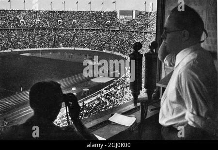 Olympia 1936, Berlin - der Sender in seinem Stand, hoch über dem Stadion voller hunderttausend Zuschauer. (Der Rundfunksprecher in seiner Zelle, hoch oben über dem Stadion, das gefllt ist mit Hunderttausend.) ©TopFoto *** Local Caption *** der Sprecher in seiner Zelle, etwa höher als das Stadion, ist mit hunderttausend Zuschauern geerfüllt. Stockfoto