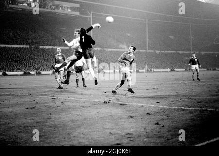 Wembley, Middlesex: England und Leeds United Spieler Jackie Charlton; (Mittelhälfte). Der westdeutsche Torhüter Hans Tilkowski wird heute Abend während des Internationalen Fußballvereins im Empire-Pool zwischen Deutschland und England in Aktion gezeigt. Das Spiel wurde bei starkem Regen und bei schlaffen Bedingungen gespielt; es wurde von einer Menge beobachtet, die auf 50,000 geschätzt wurde. 23. Februar 1966 Stockfoto