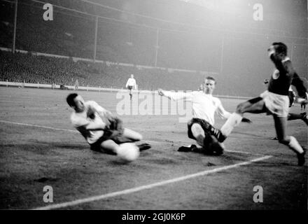 Wembley, Middlesex: England und Leicester City Torwart G. Banks; (links); und Leeds United Spieler Jackie Charlton (Mitte-Hälfte) (Mitte) und Westdeutschland und F.C. Der Kölner Spieler H. Hornig (außen links) wird während des Association International Match im Empire Pool zwischen Deutschland und England in Aktion gezeigt, während des Spiels sind sie im Einsatz. Das Spiel wurde bei starkem Regen und bei schlaffen Bedingungen gespielt; es wurde von einer Menge beobachtet, die auf 50,000 geschätzt wurde. Das Endergebnis für England lag bei 1:0, das Tor erzielte der Mitte-Vorwärts-Stiles in der 41. Minute. 23. Februar 1966 Stockfoto