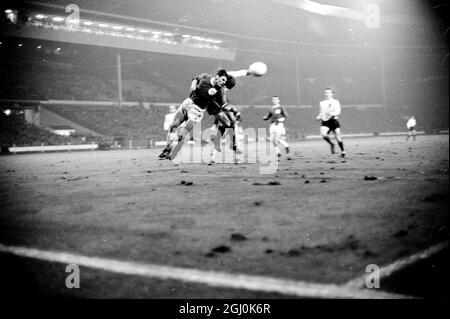 Wembley, Middlesex: Der englische Spieler Roger Hunt (Liverpool) spielt rechts innen (weißes Hemd) und der westdeutsche Spieler Wolfgang Weber (FC Köln), spielen Mitte-Hälfte in Tonights Fußball in Association International Match am Empire Pool zwischen Deutschland und England , sind in acton während des Spiels. Das Spiel wurde bei starkem Regen und bei schlaffen Bedingungen gespielt; es wurde von einer Menge beobachtet, die auf 50,000 geschätzt wurde. Das Endergebnis für England lag bei 1:0, das Tor wurde von den Stürmer der Mitte in der 41. Minute erzielt. 23. Februar 1966 23. Februar 1966 Stockfoto