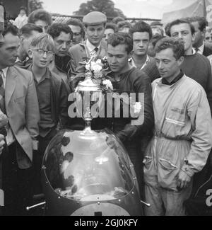 Mallory Park, Leicester: Rhodesian Motor-Cycling-Ass, Gary Hocking mit dem berühmten italienischen MV Augusta Motorrad, Lorbeeren und Cup mit seinem italienischen Motorrad-Mechaniker in den Boxen im Mallory Park (24. September), nachdem er das Rennen des Jahres mit einer Durchschnittsgeschwindigkeit von 87.72 M.P.H. gewonnen hatte. Der Senior-Champion gewann den ersten Preis von £1,000 und schlug den Briten Mike Hailwood (499 Norton) auf den zweiten Platz. 25. September1961 Stockfoto