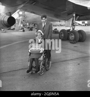 Lord David Masham schiebt den Rollstuhl seiner Frau Lady Susan Masham am Londoner Flughafen in Richtung ihres Flugzeugs. Sie tritt im Rahmen des britischen Teams an den Schwimm- und Tischtennisveranstaltungen der Paraplegiker-Olympiade in Tokio, Japan, an. 4. November 1964 Stockfoto