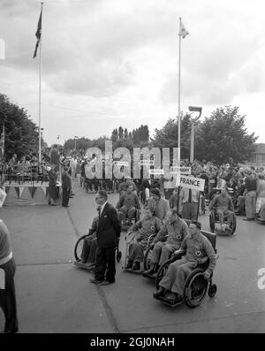 Teilnehmer der Stoke Mandeville Games aus 14 Nationen nahmen an den Stoke Mandeville Games im Nationalen Zentrum für Spinalverletzungen des Gesundheitsministeriums im Stoke Mandeville Hospital, Bucks, Teil. Es war das dritte internationale Sportfestival für Querschnittsgelähmte. Foto zeigt: Eine allgemeine Ansicht der Parade der Nationen, die am Rostrum (extreme links) vorbeiziehen, auf dem der britische Gesundheitsminister, Herr Iain Macleod, MP, steht. Juli 1954 Stockfoto