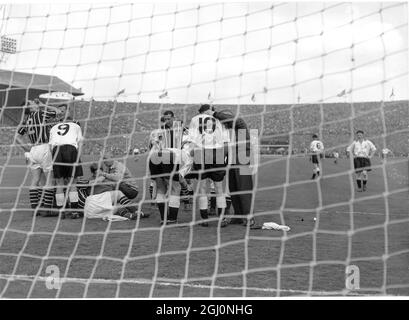 Manchester City Torhüter Bert Trautmann (c) wird vom City Trainer behandelt, nachdem er sich beim Tauchen zu Füßen von Peter Murphy (9) in Birmingham den Hals gebrochen hat. Stockfoto