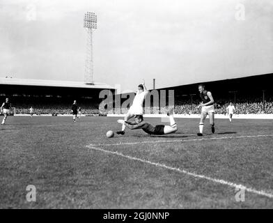 Lawrie Leslie , Torhüter von West Ham United , taucht zu Füßen von David Herd , ehemaliger Arsenal-Spieler , jetzt Mitte-vorne für Manchester United , um einen Schuss während des Spiels zwischen West Ham und Manchester United im Upton Park zu speichern . August 1961 Stockfoto