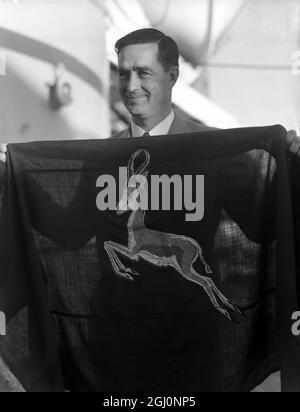 B Kenyon , der Kapitän der Springbok Rugby-Spieler, die an Bord des Liners Pretoria Castle aus Südafrika angekommen sind, hält stolz die Springbok-Flagge. Das Team ist auf Tour durch Großbritannien, Irland und Frankreich. 28. September 1951 Stockfoto