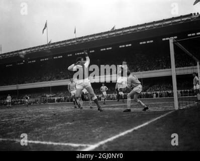 Der Arsenal-Mittelvorsteher Joe Baker (links) trifft einen Schuss auf das Tor von Manchester City - Torwart Harry Dowd bekommt jedoch während des Spiels zwischen den beiden Teams auf dem Highbury-Boden von Arsenal die Hände auf den Ball. Das Spiel ist Manchester City links-hinten Cliff Sear . 20. April 1963 Stockfoto