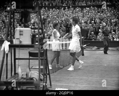 Die amerikanische Tennisspielerin, Althea Gibson, schüttelt sich nach ihrem Viertelfinalspiel im Einzel bei der Wimbledon Lawn Tennis Championship in London die Hände mit ihrer Landsfrau, Miss Shirley Fry. Miss Fry hat das Spiel gewonnen : 4 - 6 , 6 - 3 , 6 - 4 . Juli 1956 Stockfoto