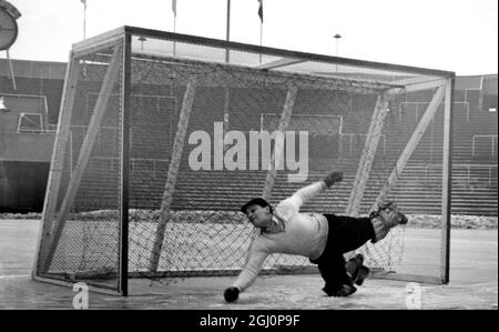 Oslo: Auf dem Eis geht der Torwart, um während eines der '' Bandy ''-Spiele im Bislett-Stadion im Zusammenhang mit den Olympischen Winterspielen zu retten. Dieses Spiel fand zwischen Schweden und Finnland . Bandy entstand in Großbritannien, wo 1891 die National Association of Bandy gegründet wurde. Das Spiel zog nach Holland und in den Norden nach Skandinavien und Russland, wo es als "Sandlot-Baseballspiel" bekannt ist. Die 11-Mann-Teams sind ähnlich wie Fußball positioniert, und die Spieler verwenden gebogene Hockeyschläger, abgesehen vom Torwart, der den Ball mit Händen, Schlittschuhe oder Körper stoppen muss. Th Stockfoto