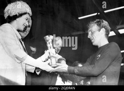 Die Königin überreicht dem englischen Kapitän einen Becher. Britiain's Queen Elizabeth II. Zeigt die Präsentation der Jules Rimet World Cup Trophy an Englands Kapitän Bobby Moore, nachdem England heute im Finale des Weltcup-Turniers im Wembley Stadium die Bundesrepublik besiegt hatte. England gewann 4-2. 30. Juli 1966 Stockfoto