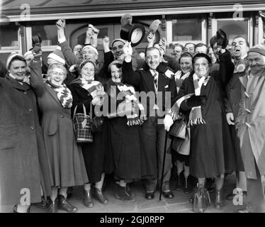 PETERBOROUGH-ANHÄNGER KOMMEN HEUTE Morgen IN LONDON an Tausende von Anhängern aus dem Norden dringen in London ein, um an den verschiedenen Cup Ties teilzunehmen, in denen ihre Teams auftreten. FOTOS ZEIGEN:- Eine glückliche Menge von Peterborough-Anhängern lächelt und trägt ihre Farben, bei ihrer Ankunft am King's Cross heute Morgen. Peterborough spielen Fulham im Craven Cottage im Cup Tie. 10. Januar 1959 Stockfoto