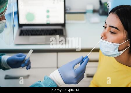 Arzt macht Abstrich Nasentest für junge Frau in der medizinischen Klinik für Coronavirus-Infektion - Fokus auf Mädchen Auge Stockfoto