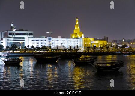 Katar, Doha. Hafen in der Nacht. Links: Finanzministerium. Rechts: Bin Zaid, auch bekannt als Spiralmoschee oder Fanar oder Qatar Islamic Culture Stockfoto