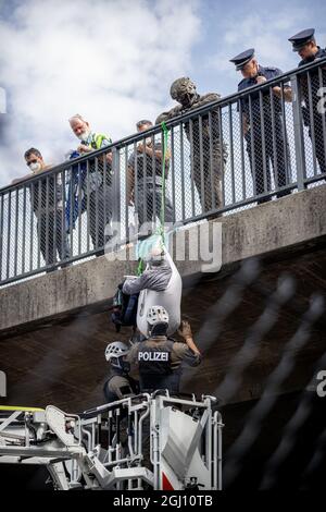 Policists hole the Aktivist*innen, which since of the Brücke compeared have herunter. Anlässlich der Eröffnung der Automobilausstellung (IAA) in München wurde am 07.09.2021 die A94 kurz vor der Ausfahrt zum Messegelände die Autobahn A94 mittels einer abseilen-Aktion von Klimaaktivist*innen blockiert. You have receive to Green washing in the Autoindustry. * am 7. September 2021 wurde die Ausfahrt zur Messe der Autobahn A94 von Klimagerechtigkeitsaktivisten blockiert. Die A94 bringt Autofahrer zur Internationalen Automobilmesse IAA in München. Sie protestieren gegen eine Stockfoto