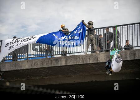 Polizei hängt Banner ab. Anlässlich der Eröffnung der Automobilausstellung (IAA) in München wurde am 07.09.2021 die A94 kurz vor der Ausfahrt zum Messegelände die Autobahn A94 mittels einer abseilen-Aktion von Klimaaktivist*innen blockiert. You have receive to Green washing in the Autoindustry. * am 7. September 2021 wurde die Ausfahrt zur Messe der Autobahn A94 von Klimagerechtigkeitsaktivisten blockiert. Die A94 bringt Autofahrer zur Internationalen Automobilmesse IAA in München. Sie protestieren gegen eine „Greenwashing“ der Automobilindustrie. (Foto von Alexander Pohl/ Stockfoto