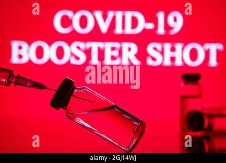 Ukraine. September 2021. In dieser Abbildung sind eine medizinische Spritze und Fläschchen vor dem Covid-19 und dem Booster Shot Logo zu sehen. Kredit: SOPA Images Limited/Alamy Live Nachrichten Stockfoto