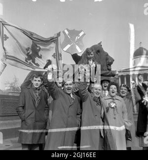 FUSSBALLFANS MIT BANNERN & ROSETTEN - FUSSBALLFAN ENGLAND V SCHOTTLAND JUBELT ÜBER MENSCHENMENGEN AM TRAFALGAR SQUARE IN LONDON ; 6. APRIL 1963 Stockfoto