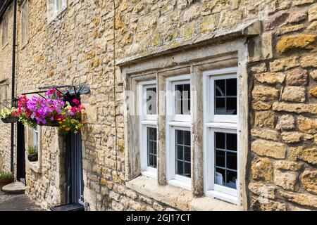 Mullionfenster und Blumenkörbe auf denkmalgeschütztem Haus in Batheaston, Somerset, Großbritannien Stockfoto