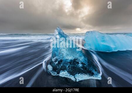 Diamant-Tafelenten aus kalbenden Eisbergen am schwarzen Sandstrand von Jokulsarlon in Südisland Stockfoto