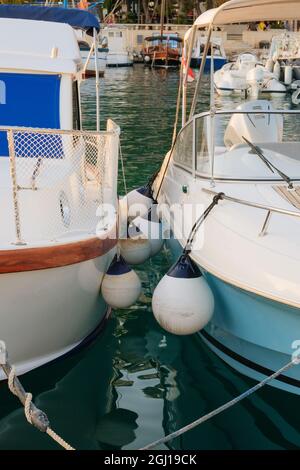 Bojen zwischen Booten an der Küste des Ozeans im Hafen Dock. Sommerurlaub und Yachting. Stockfoto