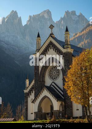 Chiesa di San Sebastiano in Falcade im Val Biois, im Hintergrund das Focobon-Gebirge, Pale di San Martino. Italien. Stockfoto