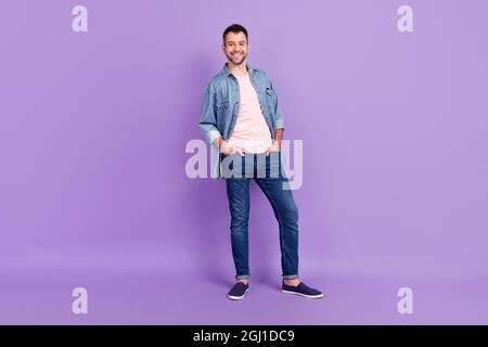 In voller Länge Körpergröße Foto Mann lächelnd zuversichtlich tragen Denim Jacke isoliert pastellvioletten Hintergrund Stockfoto