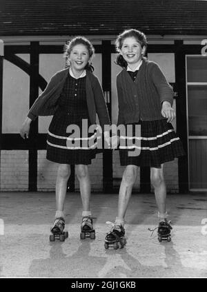 Die Pferdeschwanzzwillinge Susan und Sandra Owen können nur durch den Maulwurf hinter Sandras Ohr getrennt werden, daher der Grund für ihre Frisur. Beide eineiigen Zwillinge sind Roller Skating in eineiigen Outfits gesehen. 19 Mai 1965 Stockfoto