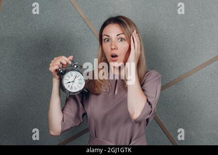 Geschäftsfrau junger Erwachsener Trainer mit Uhr am Büroportrait. Zeitmanagement-Konzept Stockfoto