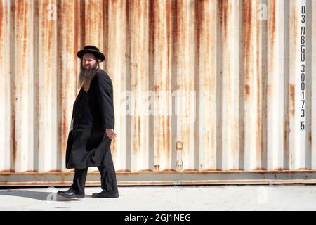 Ein chassidischer Mann, wahrscheinlich ein Satmarer Rabbi, geht entlang der Lee Avenue in Williamsburg, Brooklyn, New York. Stockfoto