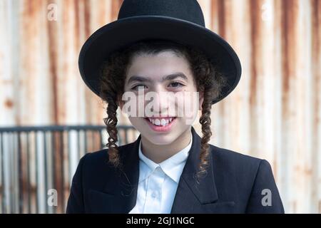 Porträt eines jungen chassidischen jüdischen Jungen mit Sommersprossen. Auf der Lee Avenue in Williamsburg, Brooklyn, New York. Stockfoto