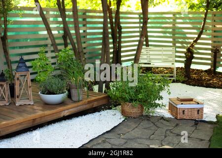 Gemütliche Gartenecke. Herbst Hinterhof Haus. Terrasse mit Pflanzen und hölzernen Veranda des Hauses. Terrasse des Hauses mit Pflanzen in Töpfen. Stockfoto