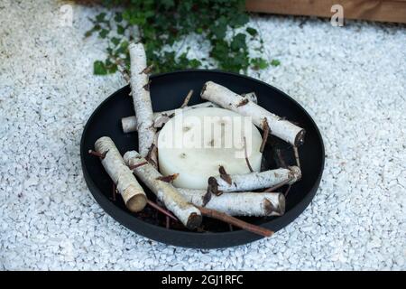 Metall schwarzen Kamin Schüssel im Garten auf Hinterhof Rasen. Eisen runde Feuerstelle auf Hinterhof Party Platz. Feuerstelle und Kamin Stockfoto