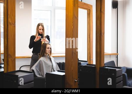 Der Friseurmeister schneidet die Haarspitzen nach dem Waschen und im Schönheitssalon. Stockfoto