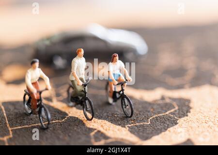 Miniaturmenschen Reisende mit Fahrrad auf der Weltkarte Hintergrund Stockfoto