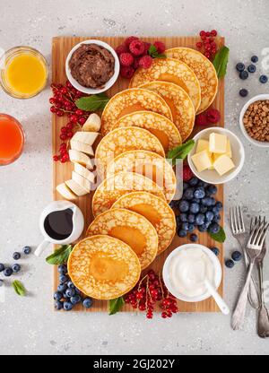 amerikanisches Pfannkuchenbrett mit Speck, Beeren, Ahornsirup, Butter Stockfoto