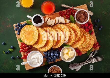 amerikanisches Pfannkuchenbrett mit Speck, Beeren, Ahornsirup, Butter Stockfoto