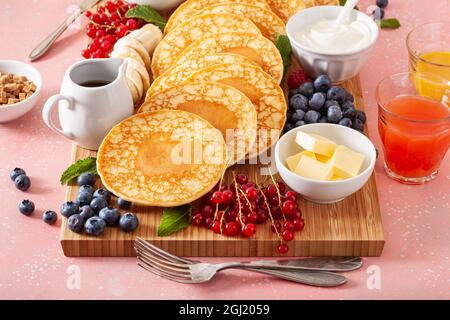 amerikanisches Pfannkuchenbrett mit Speck, Beeren, Ahornsirup, Butter Stockfoto