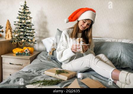 Mädchen Verpackung Geschenke mit Weihnachtsdekoration.Geschenk in einer Box, ein Brief in einem Handwerk Umschlag. Stockfoto