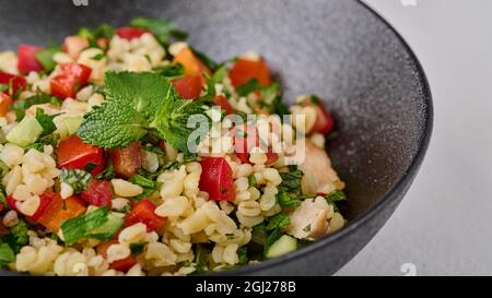 Macro Middle Eastern traditionelle Salattabbouleh aus Bulgur oder Couscous. Selektiver Fokus Stockfoto