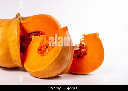 Frisch geschnitter, orangefarbener großer Kürbis auf weißem Hintergrund, Nahaufnahme. Bio-Landwirtschaftsprodukt, Zutaten zum Kochen, gesundes Essen vegan. Stockfoto