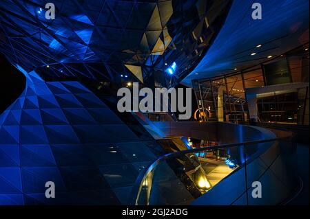 MÜNCHEN, DEUTSCHLAND - 19. Aug 2021: Die BMW-Welt München als Teil der BMW-Zentrale in München, Deutschland, blau beleuchtet Stockfoto