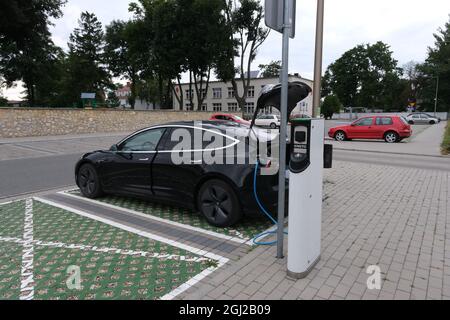 Strzelce Opolskie, Polen - 20. August 2021: Eine statische Aufnahme eines schwarzen Tesla Model 3 mit zwei Motoren, der an der ENSTO AC-Ladestation geladen wird Stockfoto