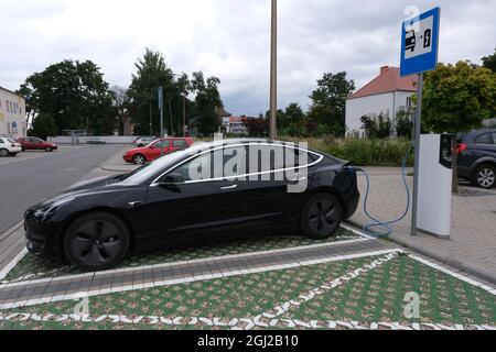 Strzelce Opolskie, Polen - 20. August 2021: Eine statische Aufnahme eines schwarzen Tesla Model 3 mit zwei Motoren, der an der ENSTO AC-Ladestation geladen wird Stockfoto