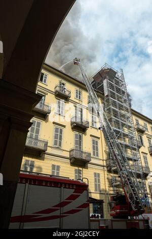 Das Feuer in Turin zerstört den historischen Palast gegenüber dem Bahnhof Porta Nuova. Feuerwehrleute werden aktiviert und arbeiten unaufhörlich daran, sie zu kontrollieren. Stockfoto