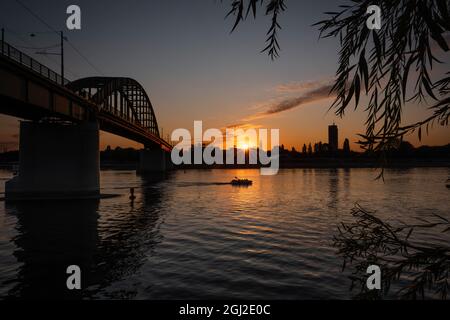 Eisenbrücke über die Donau in Belgrad bei Sonnenuntergang Stockfoto