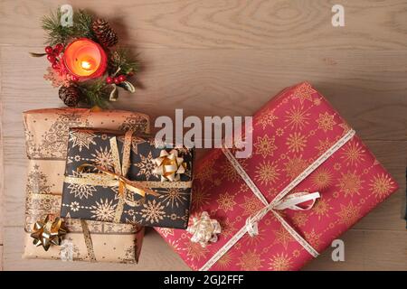 Kerze, Dekoration und die Weihnachts-Geschenkschachteln auf einer braunen Holzfläche von oben betrachtet Stockfoto