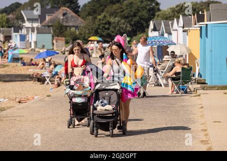 Sonnenanbeter auf ihren Strandhütten in Hamworthy, in der Nähe von Poole, Dorset, genießen die Mini-Hitzewelle im Herbst, England, Großbritannien Stockfoto