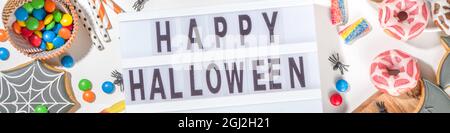 Set aus verschiedenen klassischen Halloween-Leckereien auf weißem Hintergrund. Auswahl Sortiment traditionelle Kekse, Lebkuchen, Süßigkeiten, Süßigkeiten und Deko-Kürbisse. Stockfoto