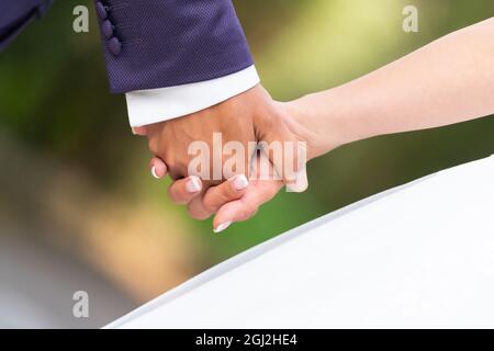 Nahaufnahme der Hände des Bräutigams und der Braut beim Gehen Stockfoto